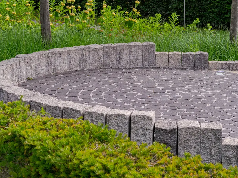 Round paver patio with a stone border